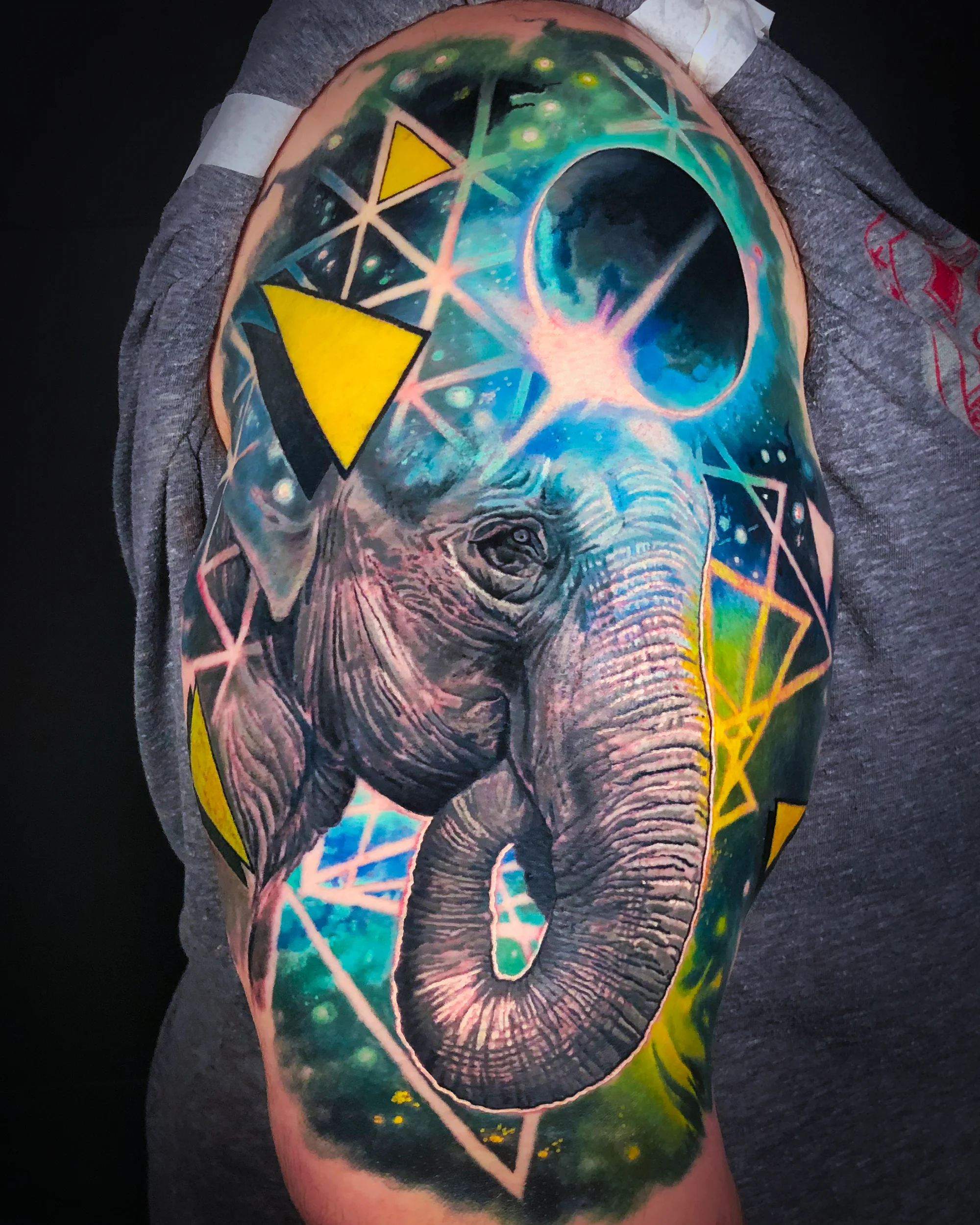 Color realism geometric space elephant thigh tattoo by Austin tattoo artist Bobby Cupparo