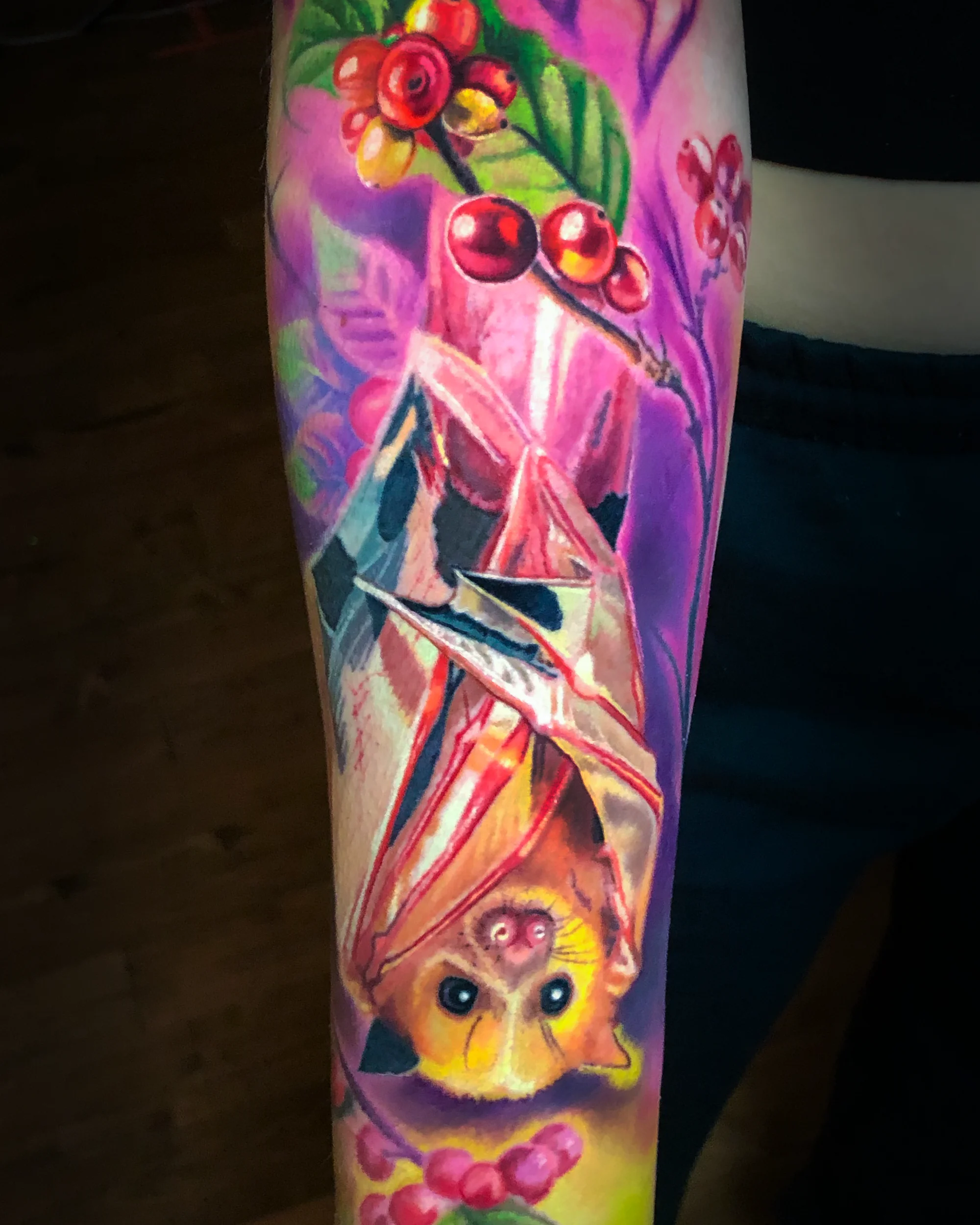Color realism fruit bat with botanical berries forearm tattoo by Austin tattoo artist Bobby Cupparo