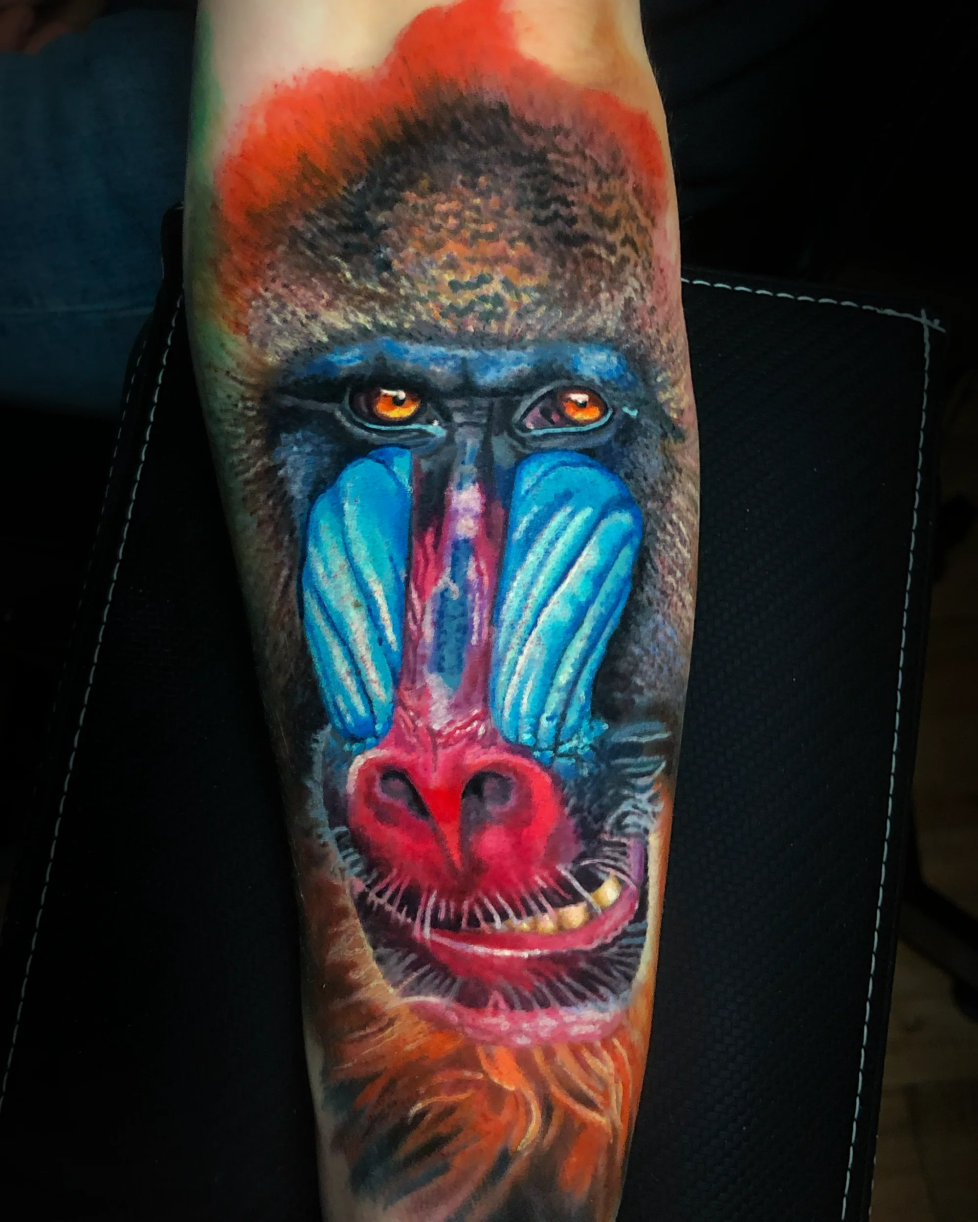 Color realism mandrill baboon face forearm tattoo by Austin tattoo artist Bobby Cupparo