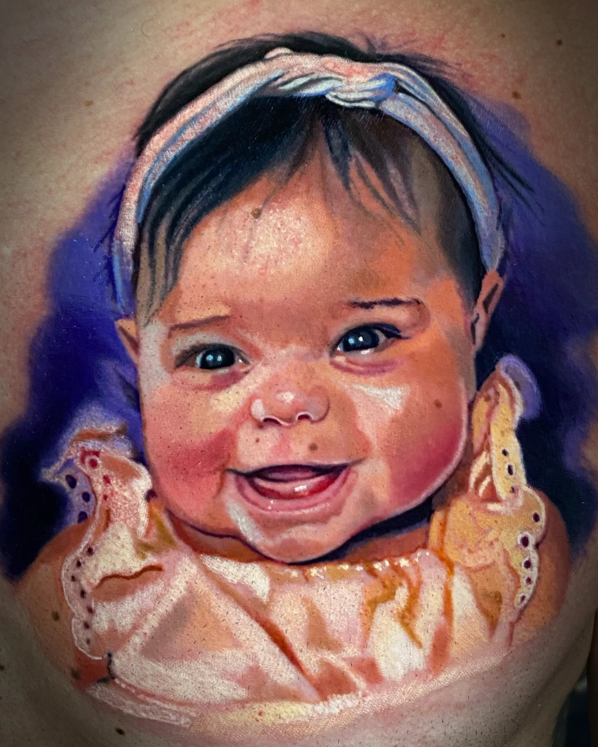 Color realism photorealistic baby girl portrait forearm tattoo by Austin tattoo artist Bobby Cupparo