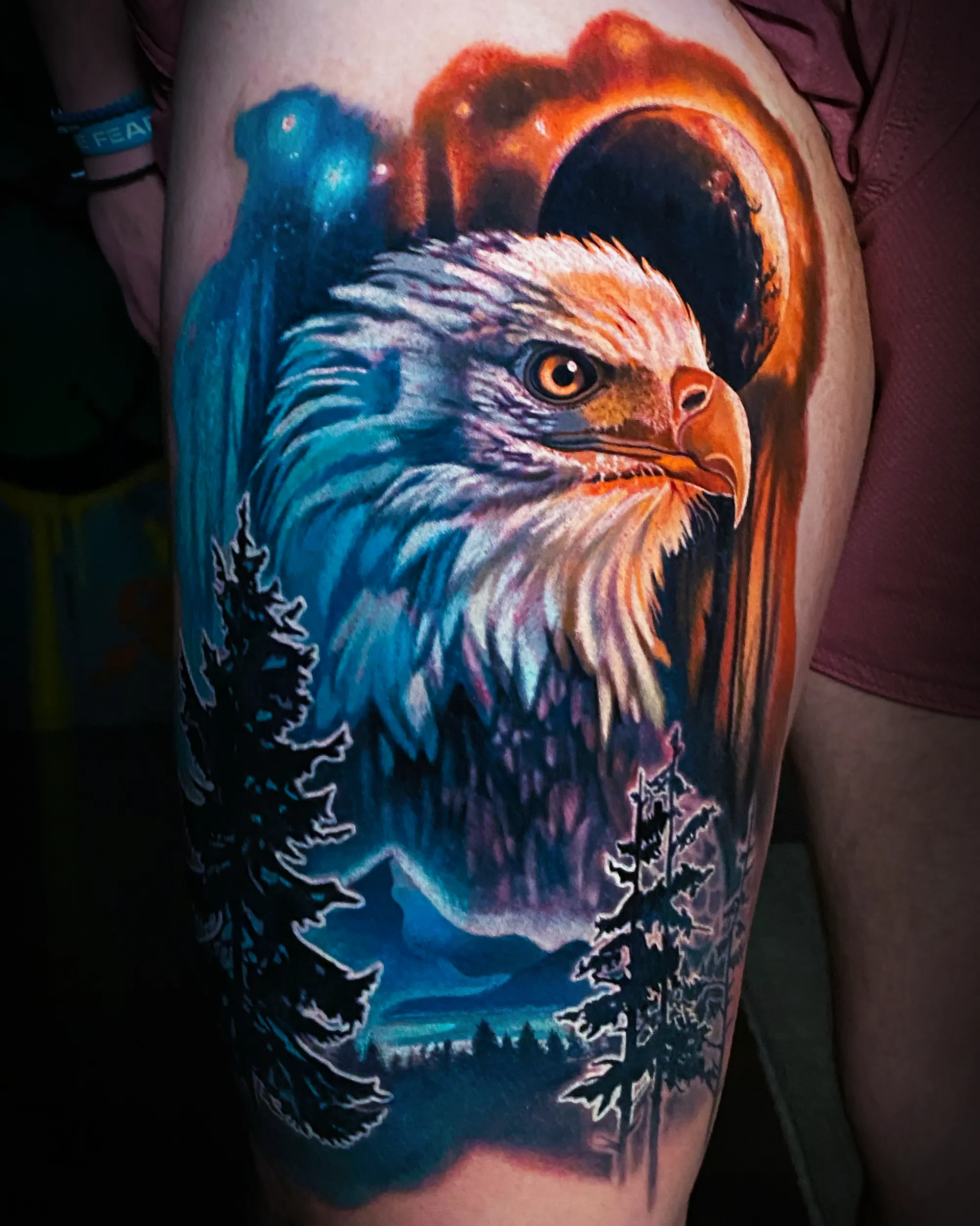 Color realism bald eagle with glowing moon forest landscape thigh tattoo by Austin tattoo artist Bobby Cupparo