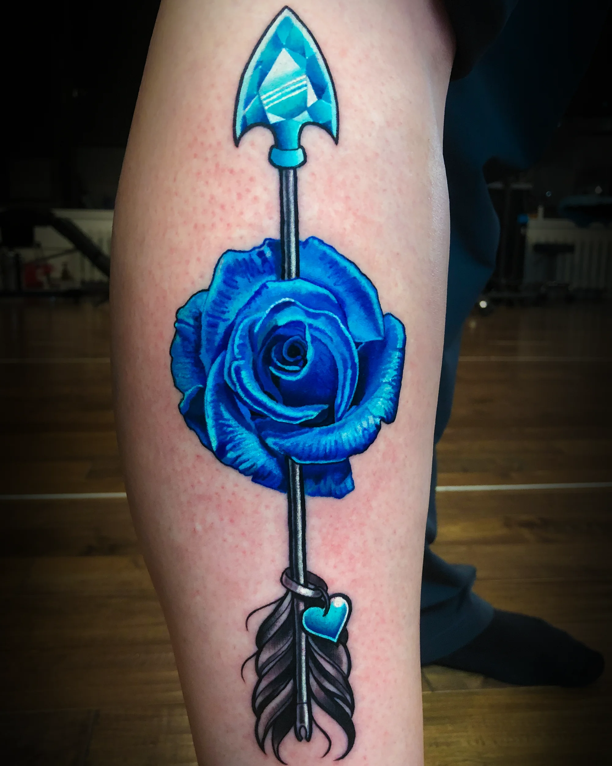 Color realism blue rose with crystal diamond arrow shin tattoo by Austin tattoo artist Bobby Cupparo