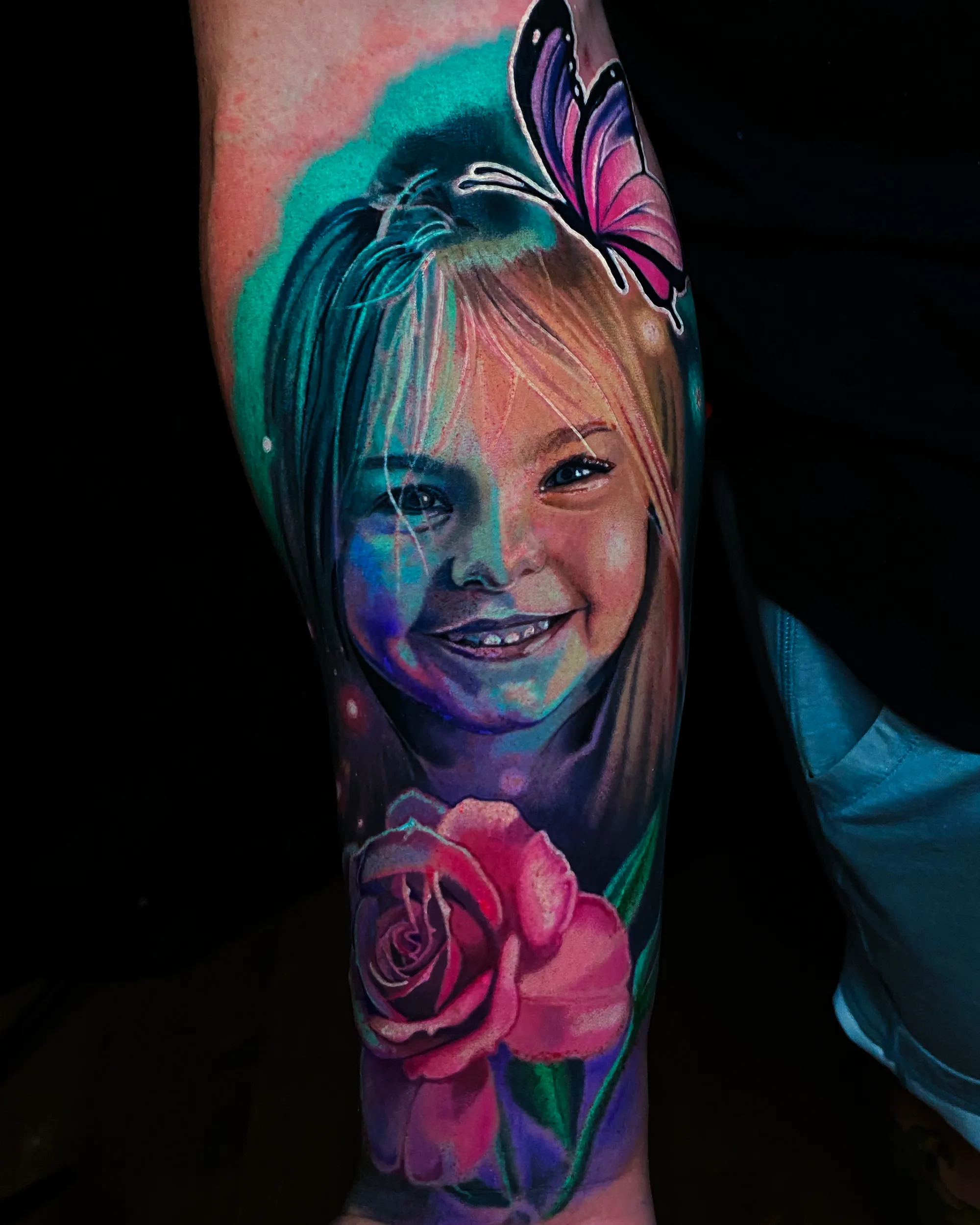 Color realism child girl portrait with butterfly and rose forearm tattoo by Austin tattoo artist Bobby Cupparo