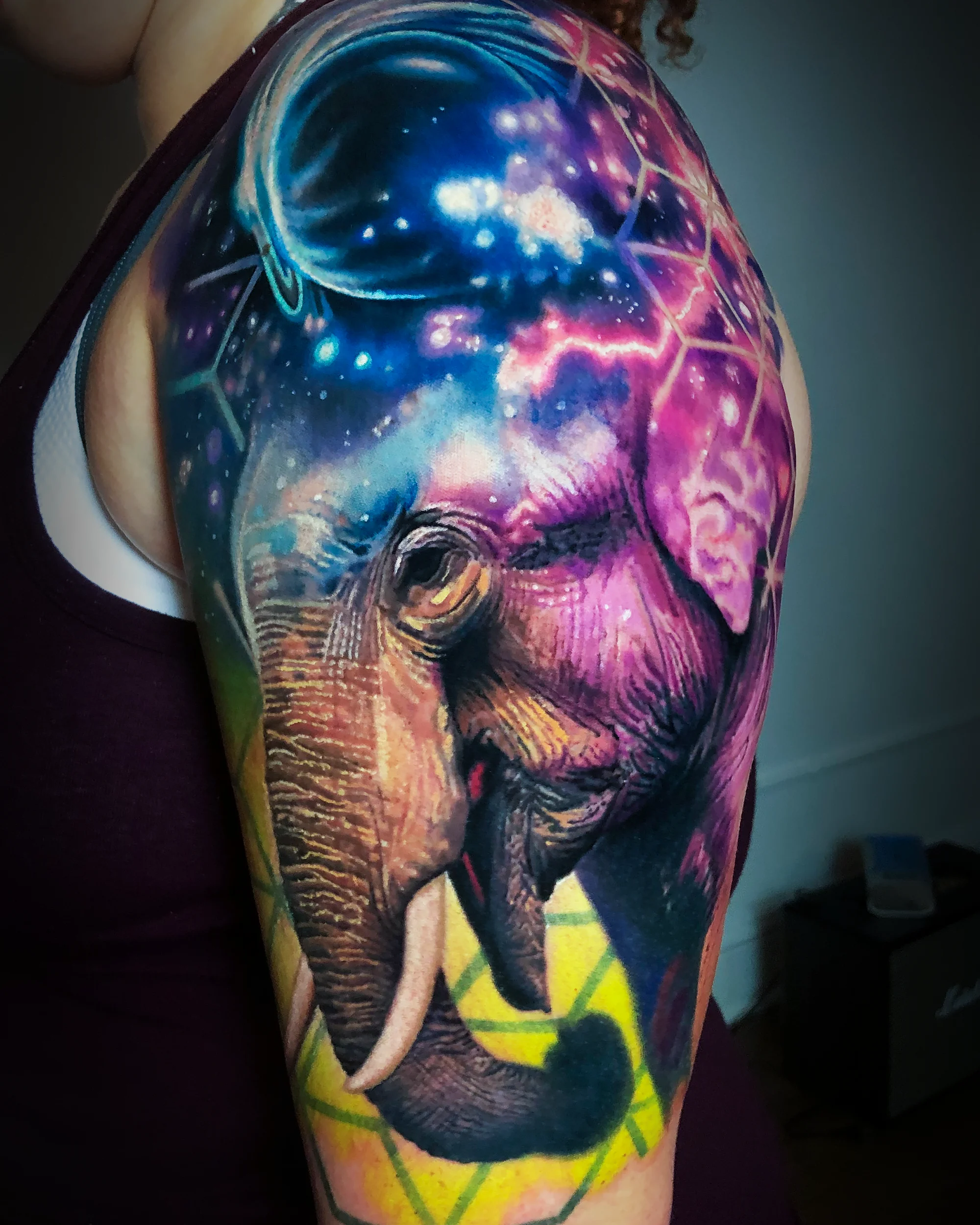 Color realism galaxy elephant upper arm tattoo by Austin tattoo artist Bobby Cupparo