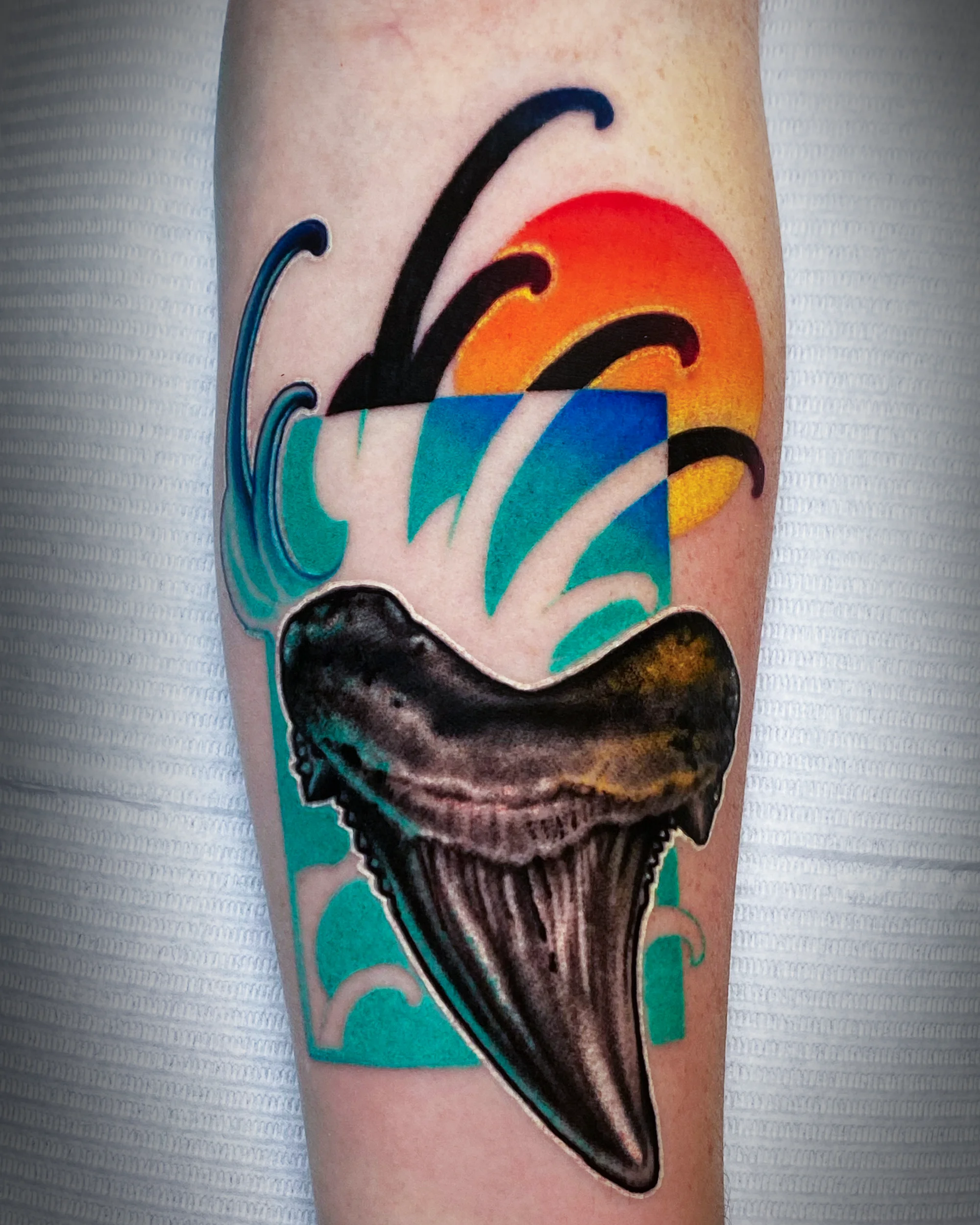 Color realism megalodon shark tooth retro ocean forearm tattoo by Austin tattoo artist Bobby Cupparo
