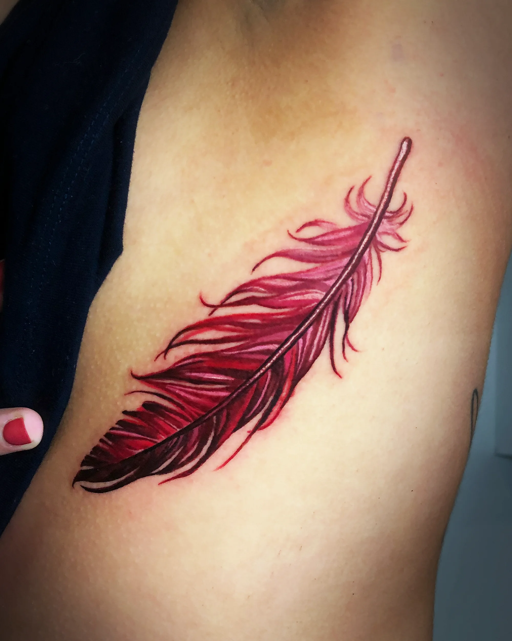Red feather ribs tattoo