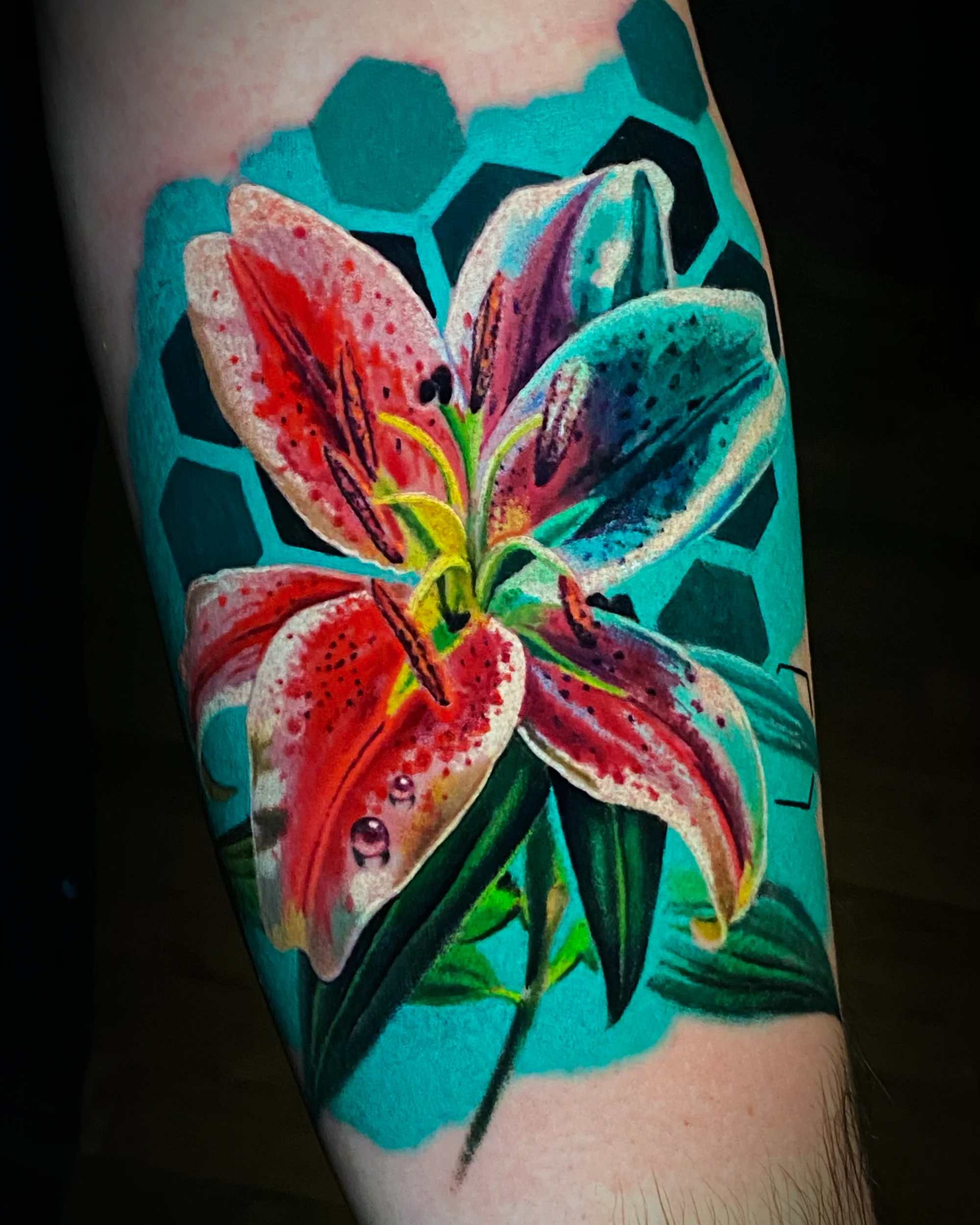 Color realism stargazer lily hexagon teal forearm tattoo by Austin tattoo artist Bobby Cupparo