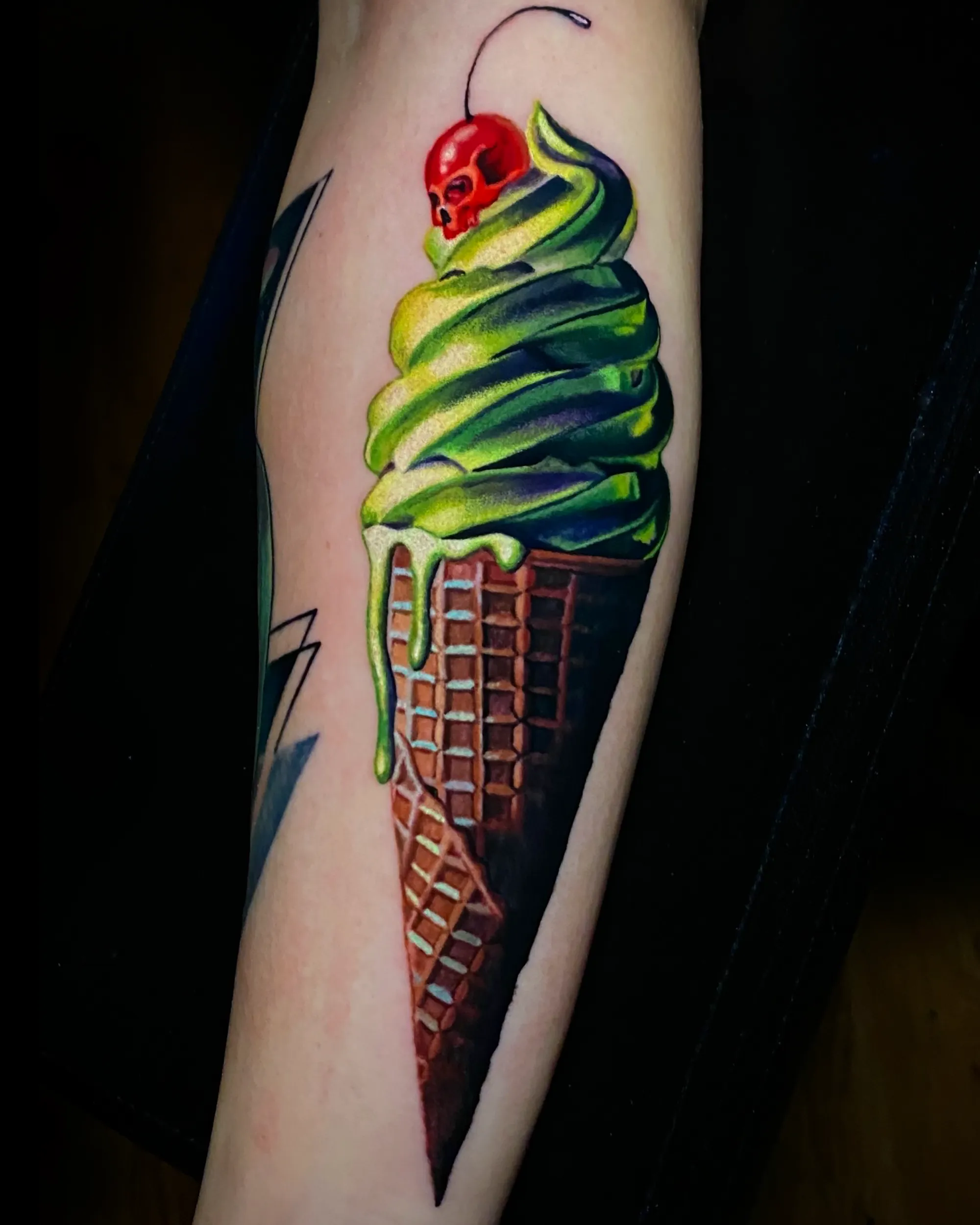Color realism swirl ice cream forearm tattoo by Austin tattoo artist Bobby Cupparo