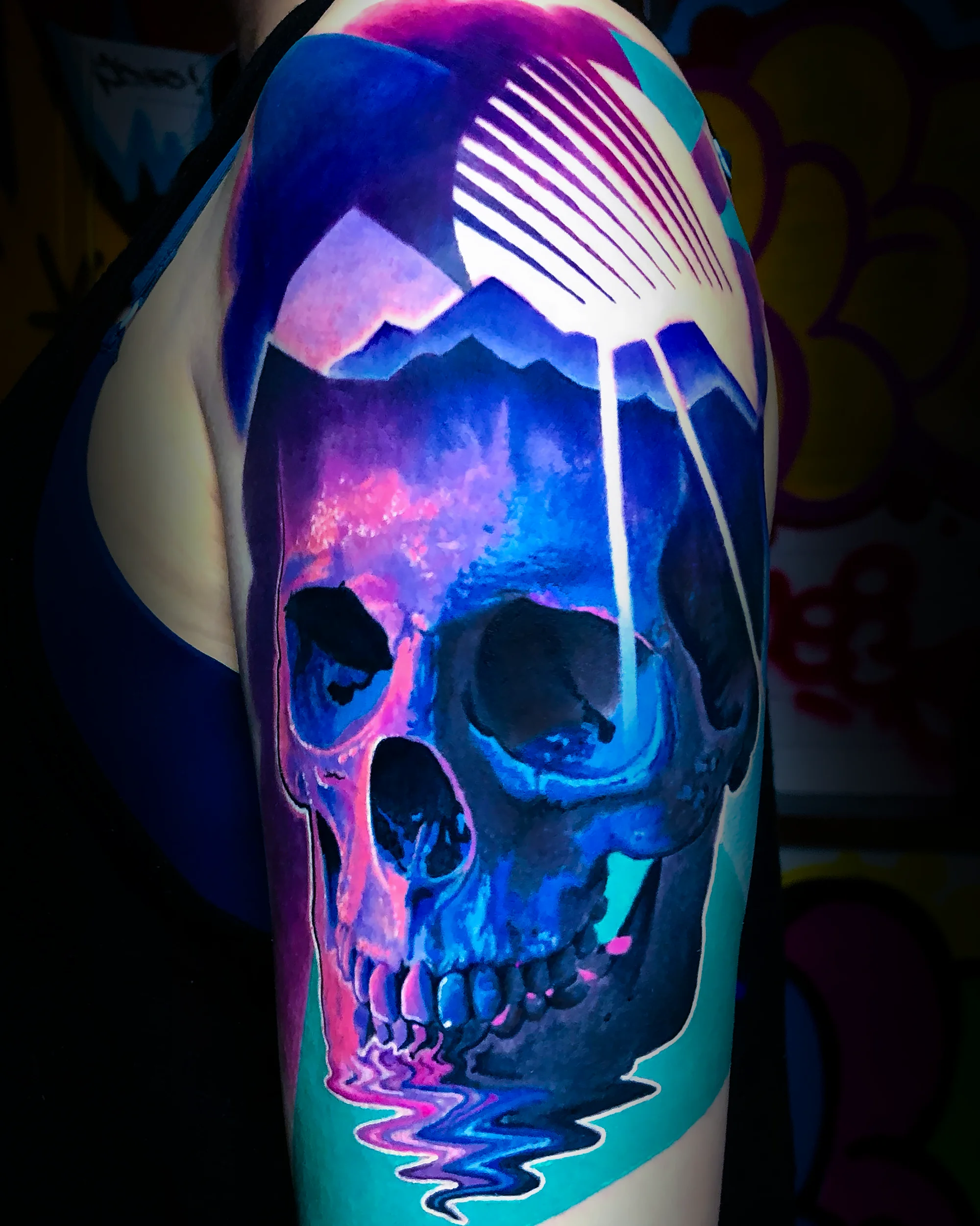 Surreal color synthwave skull with mountain retro grid upper arm tattoo by Austin tattoo artist Bobby Cupparo