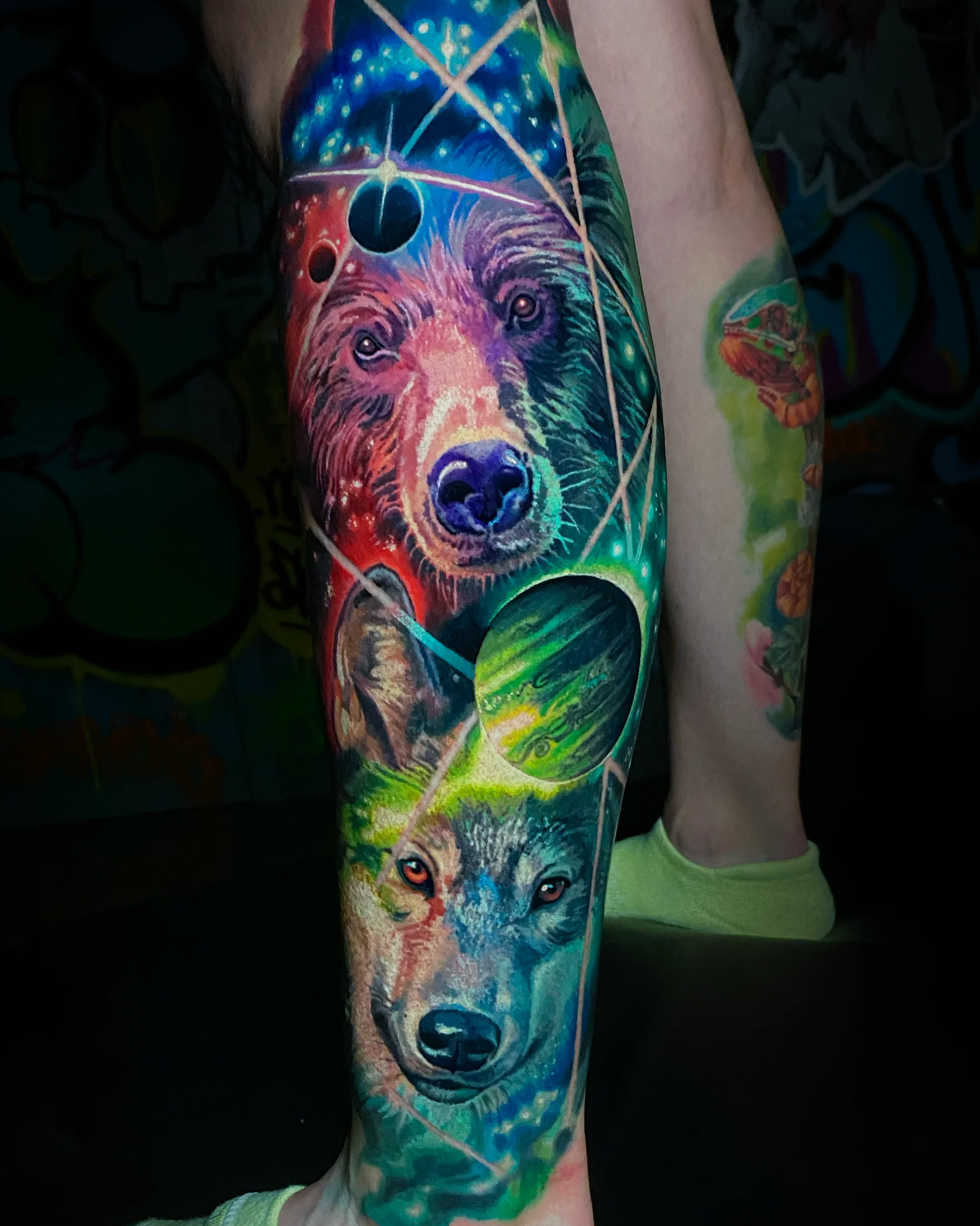 Surreal color galaxy bear and wolf calf sleeve tattoo by Austin tattoo artist Bobby Cupparo