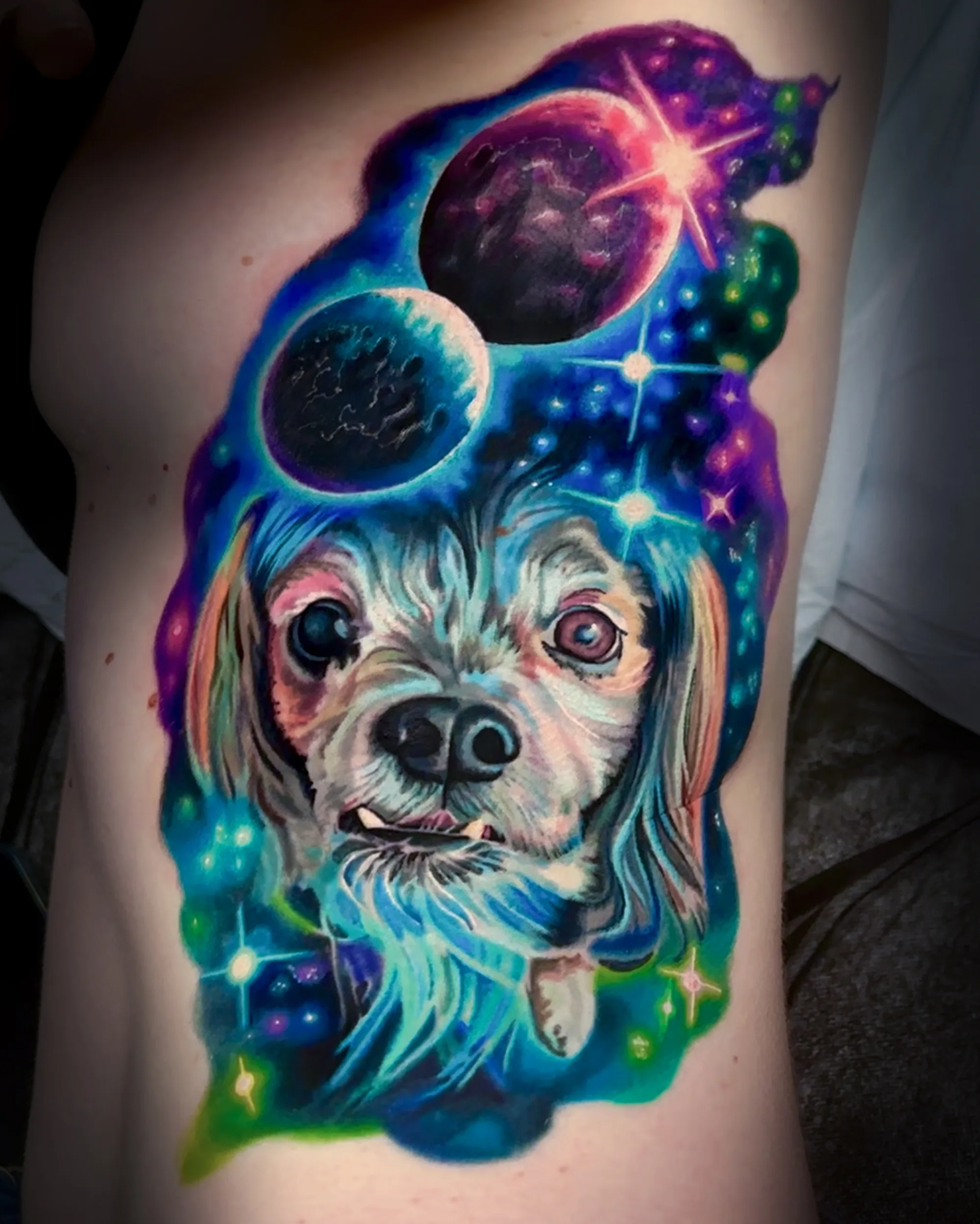 Color realism cosmic dog portrait with planets and stars, galaxy cover-up tattoo on the ribs by Austin tattoo artist Bobby Cupparo