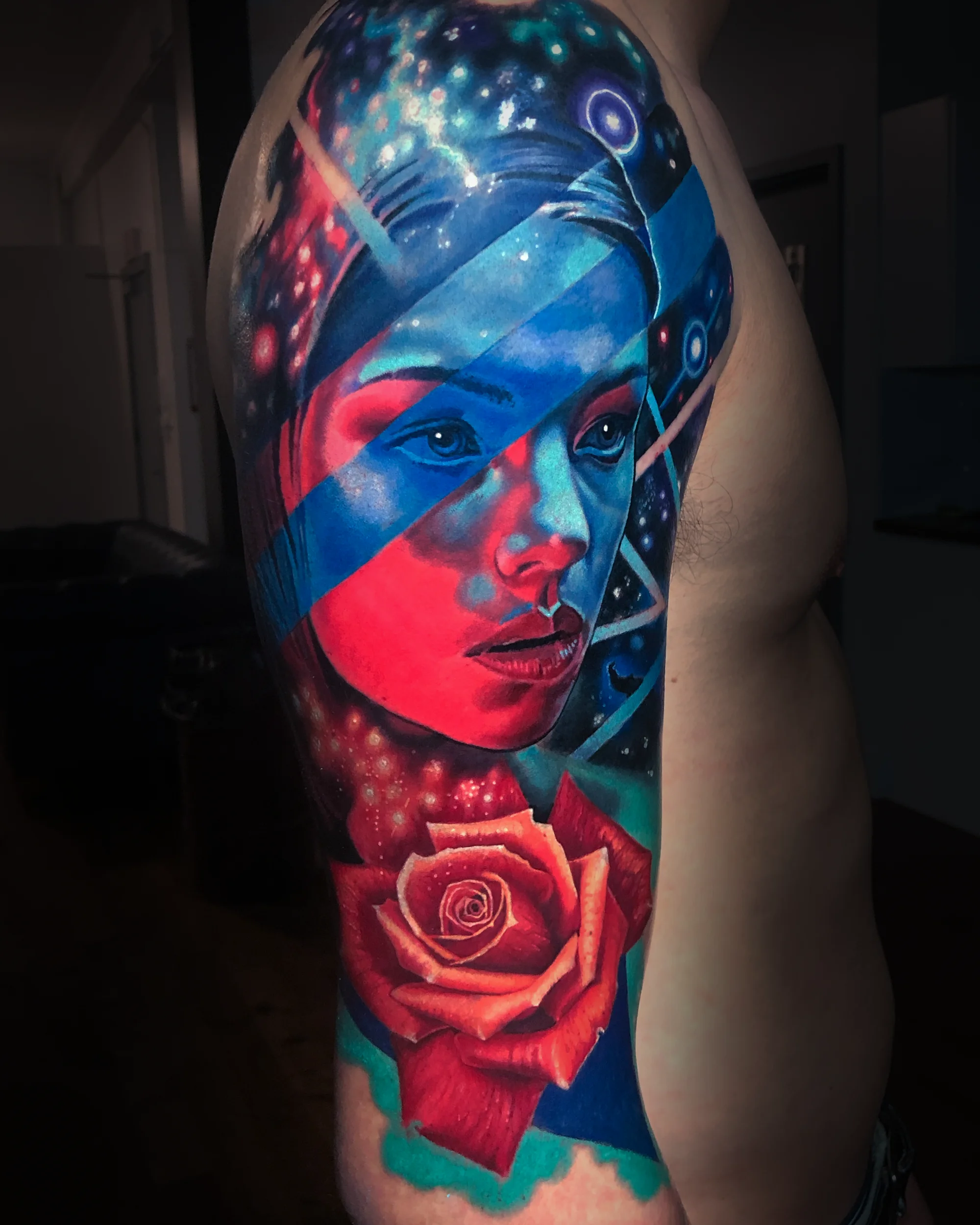 Color realism cosmic female portrait with rose upper arm tattoo by Austin tattoo artist Bobby Cupparo