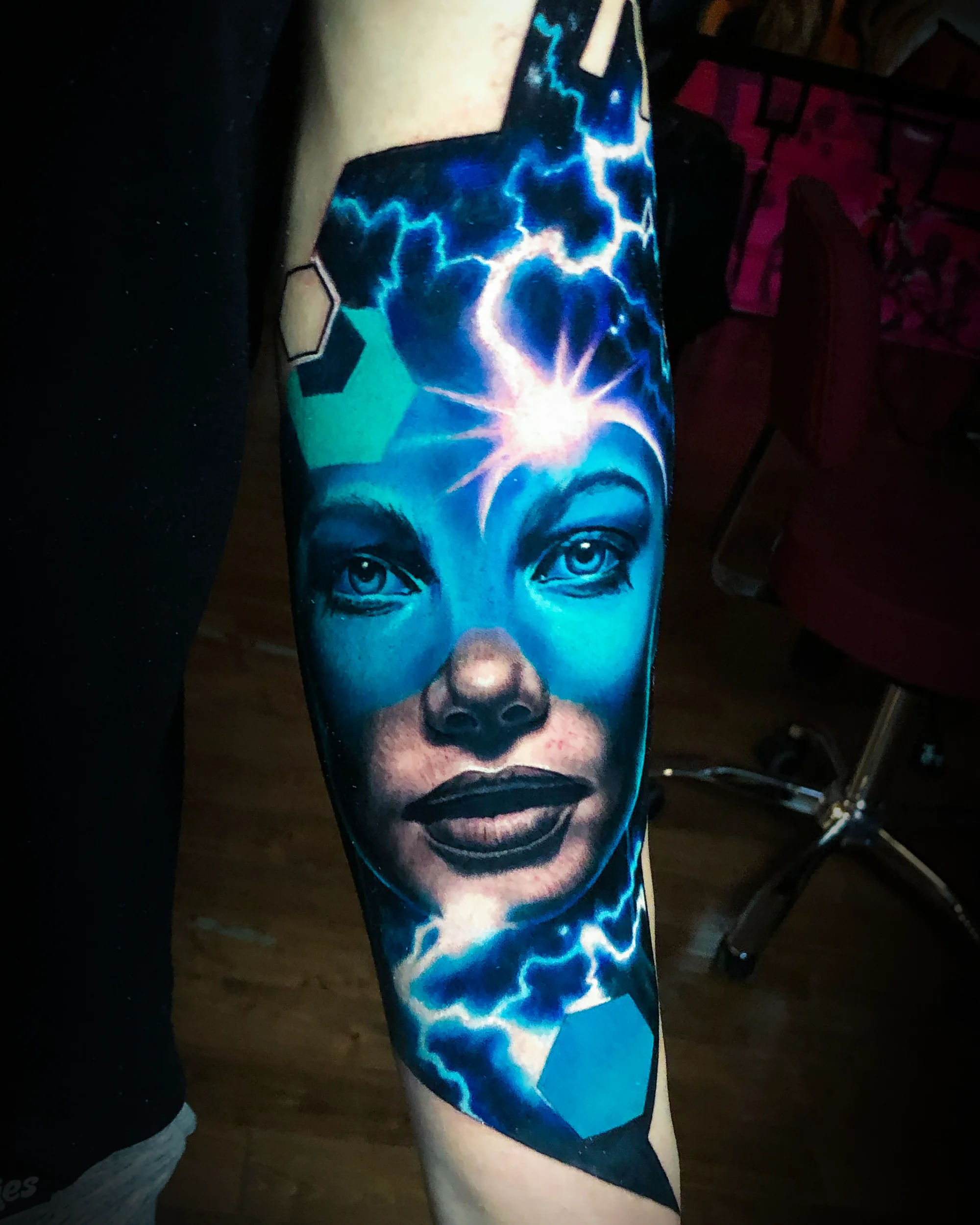 Surreal color realism cosmic woman with lightning forearm tattoo by Austin tattoo artist Bobby Cupparo