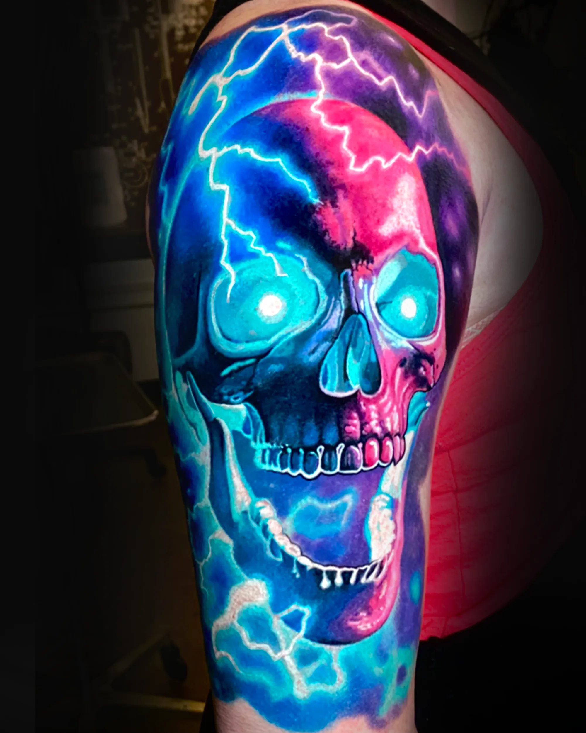 Surreal color electric skull upper arm tattoo by Austin tattoo artist Bobby Cupparo