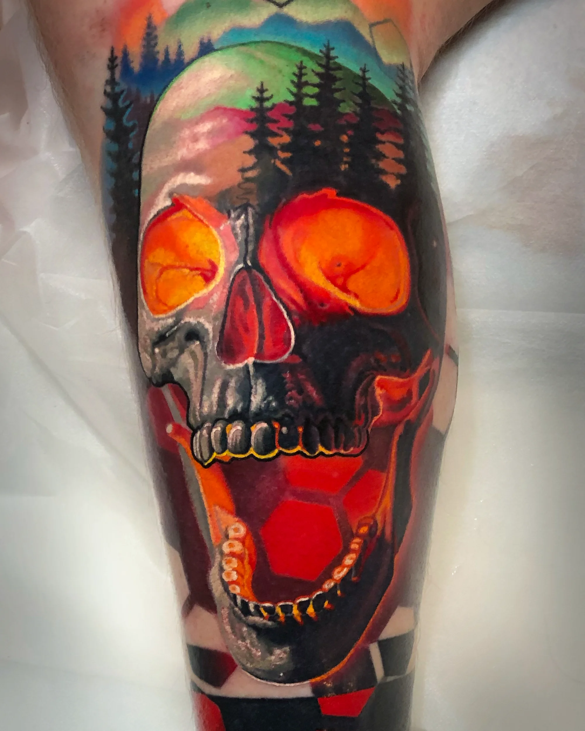 Surreal color forest skull with neon aurora upper arm tattoo by Austin tattoo artist Bobby Cupparo
