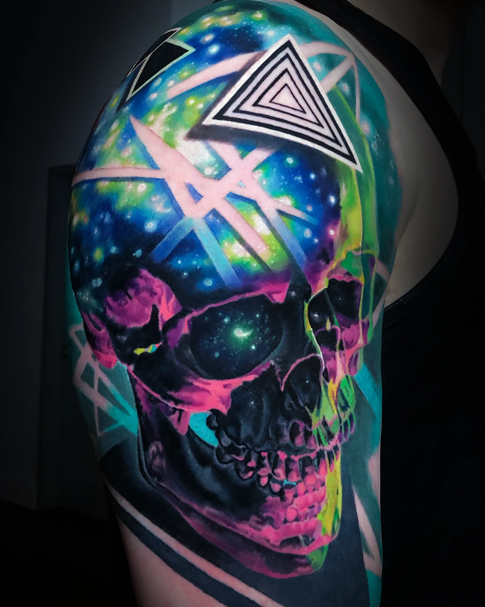 Surreal color galaxy skull geometric triangle upper arm tattoo by Austin tattoo artist Bobby Cupparo