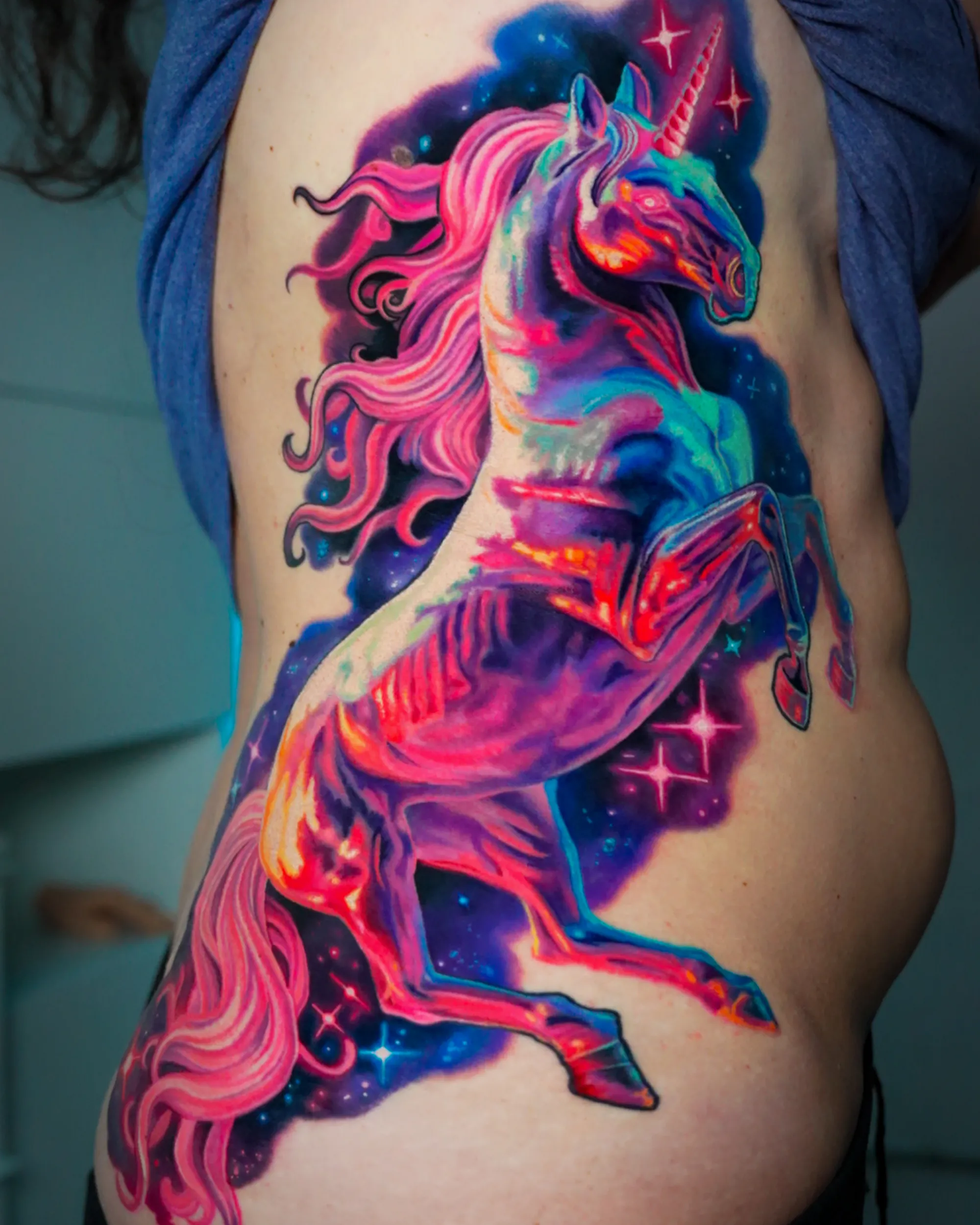 Surreal color galaxy unicorn rib tattoo by Austin tattoo artist Bobby Cupparo