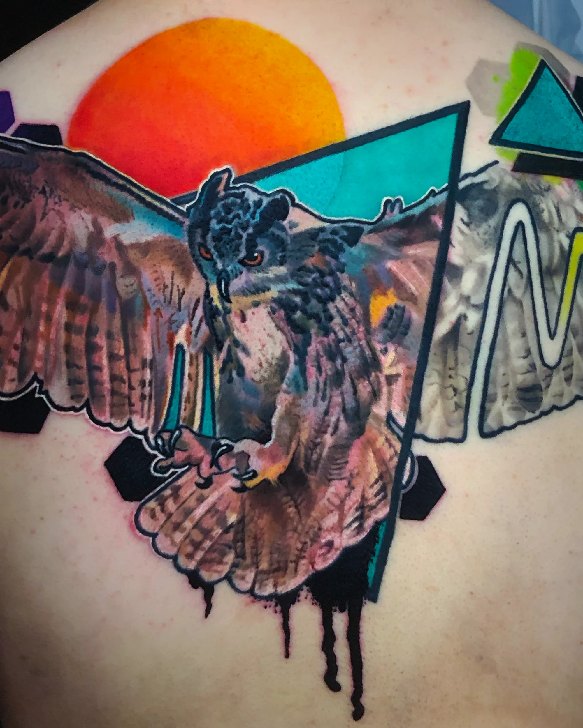 Surreal color geometric owl in flight with sunset upper back tattoo by Austin tattoo artist Bobby Cupparo
