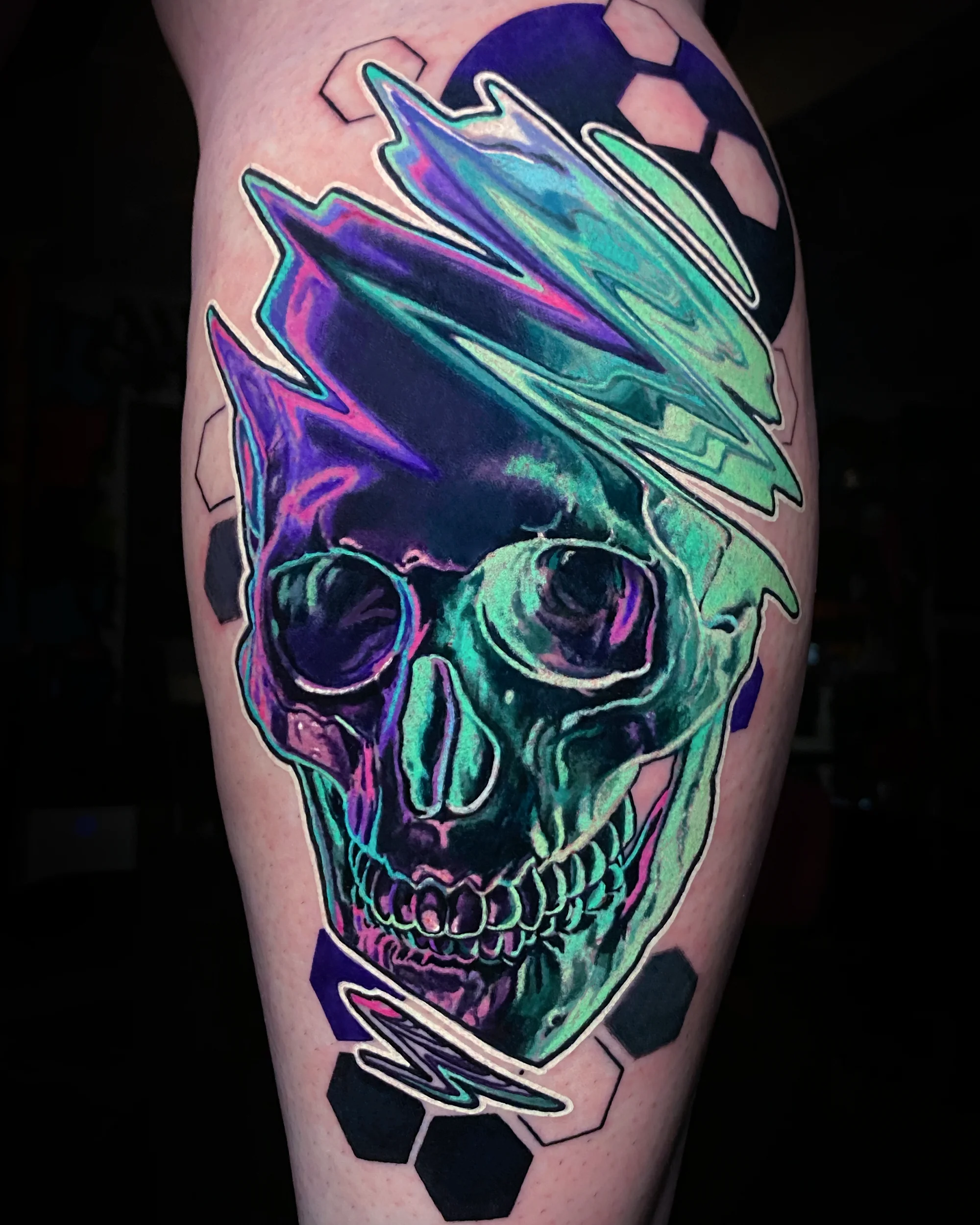 Surreal color glitch skull iridescent neon shin tattoo by Austin tattoo artist Bobby Cupparo