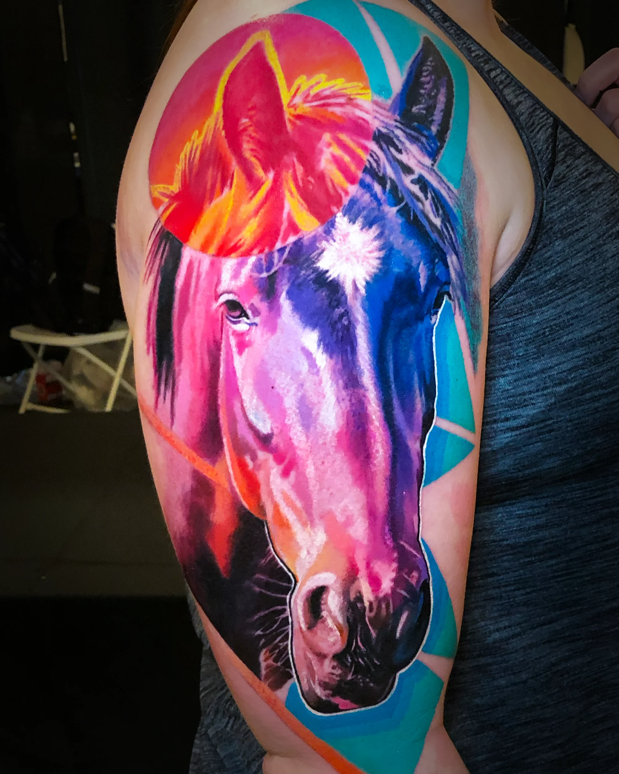 Surreal color horse portrait upper arm tattoo by Austin tattoo artist Bobby Cupparo