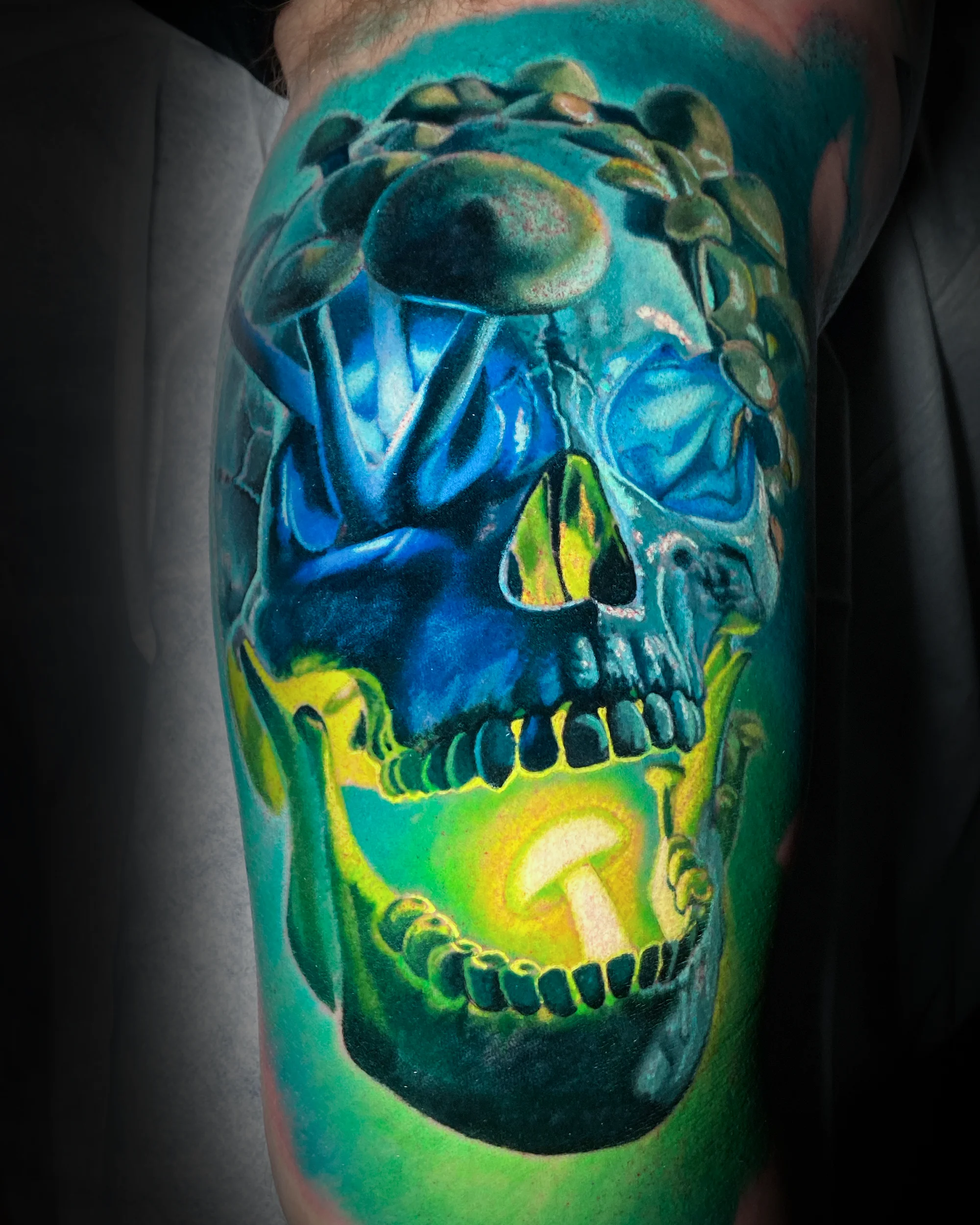 Surreal color psychedelic mushroom skull teal green thigh tattoo by Austin tattoo artist Bobby Cupparo