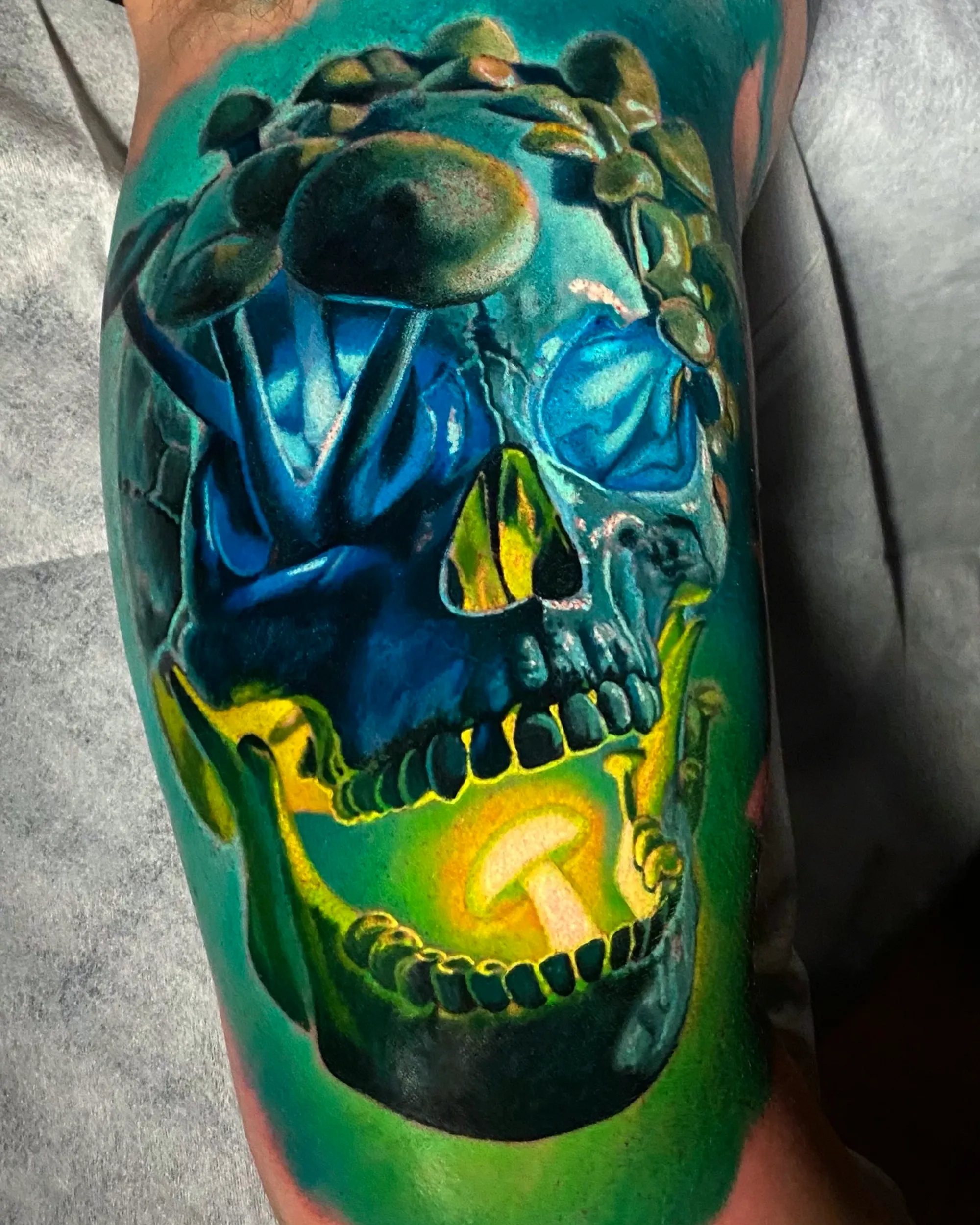 Surreal color mushroom skull thigh tattoo by Austin tattoo artist Bobby Cupparo