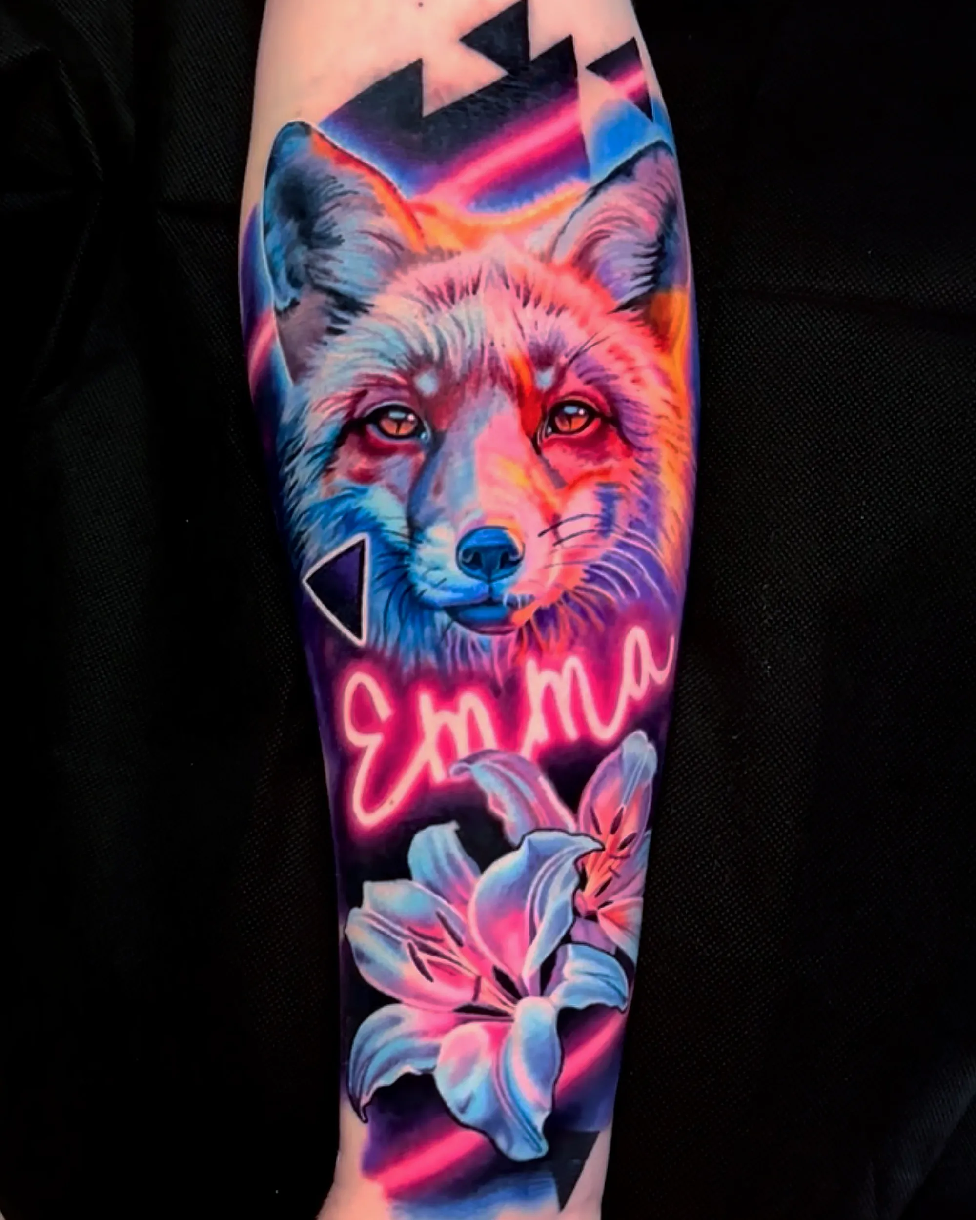 Surreal color realism neon fox with lily forearm tattoo by Austin tattoo artist Bobby Cupparo