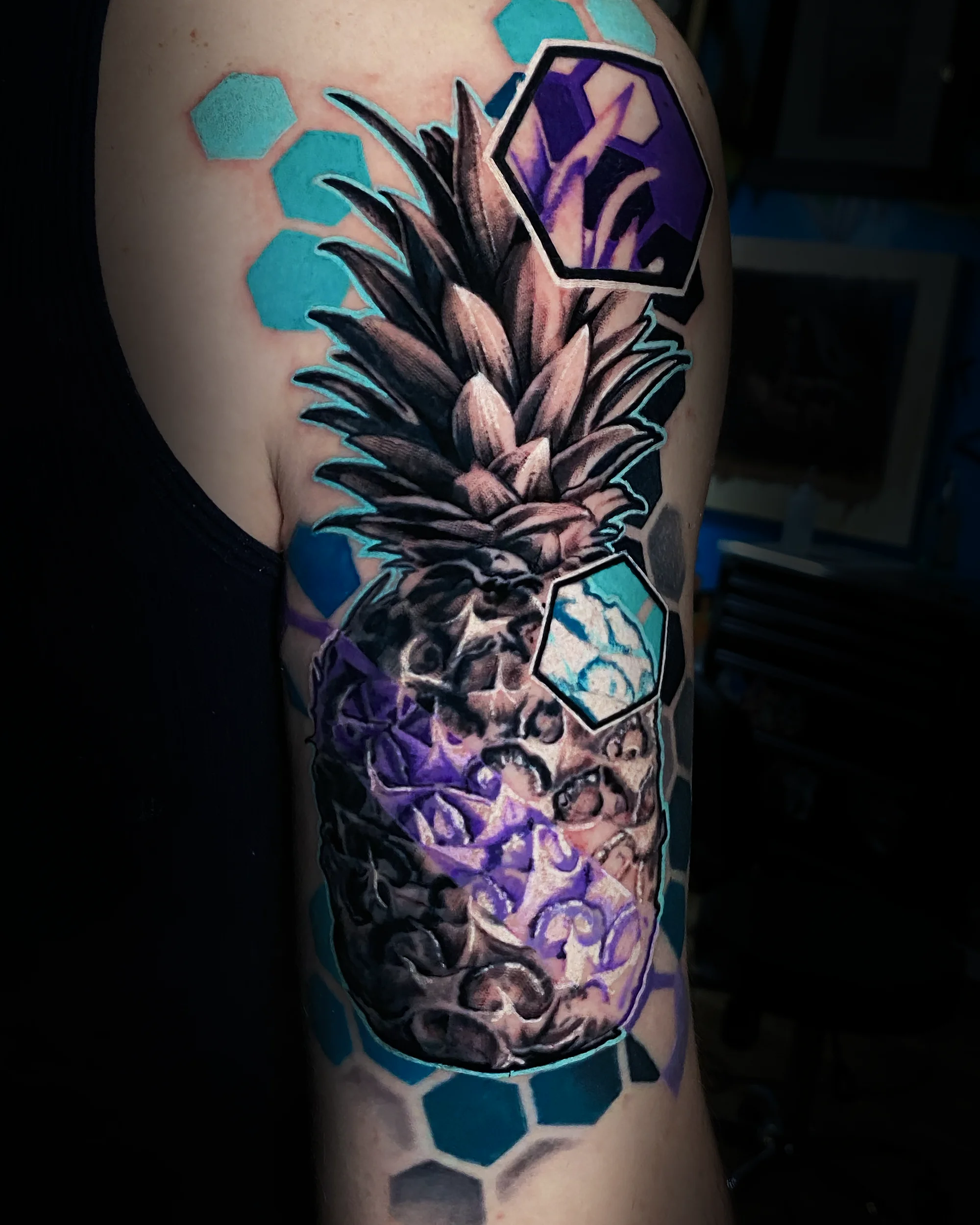 Surreal color geometric pineapple skull hexagon upper arm tattoo by Austin tattoo artist Bobby Cupparo