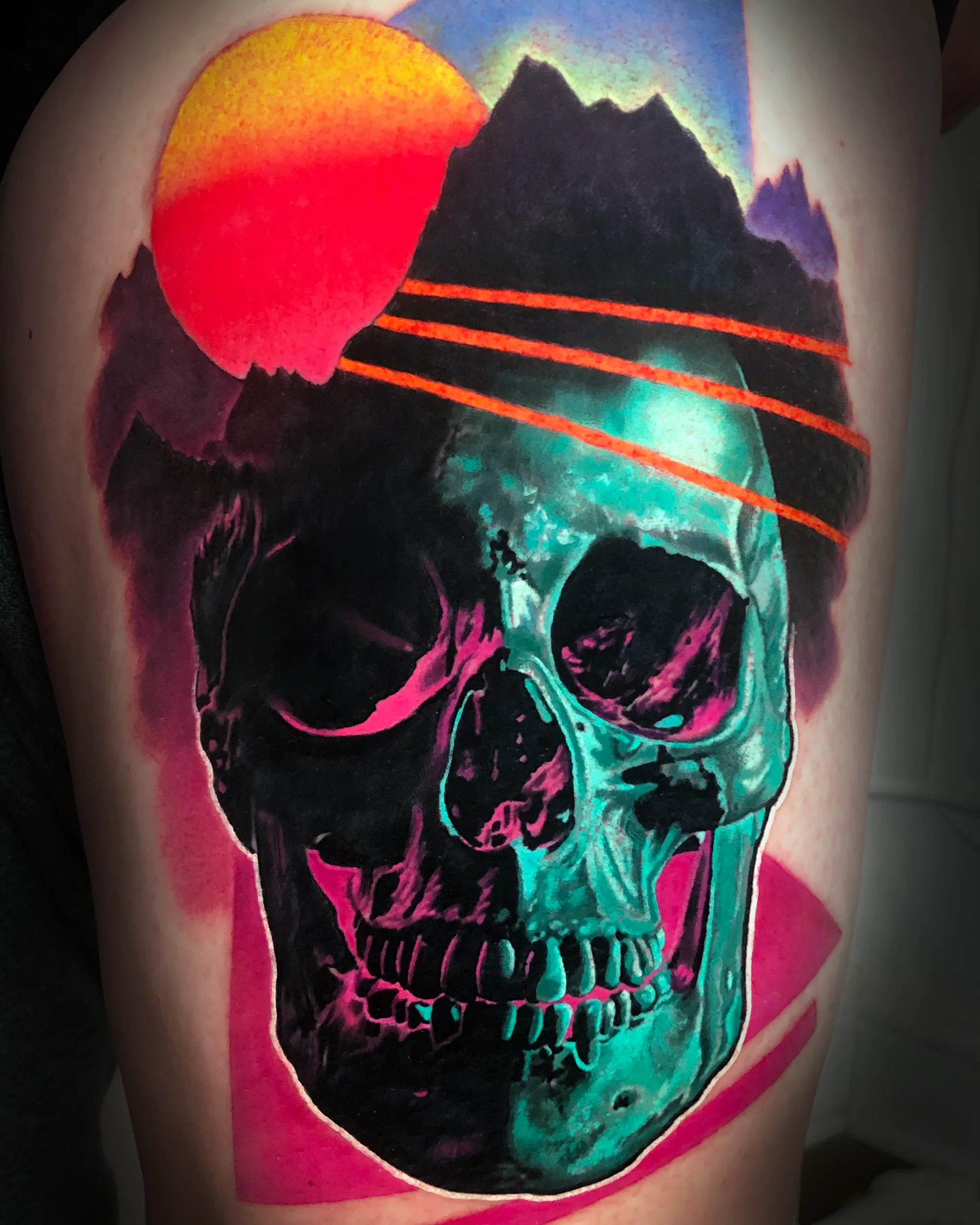 Surreal color retro synthwave skull mountain thigh tattoo by Austin tattoo artist Bobby Cupparo
