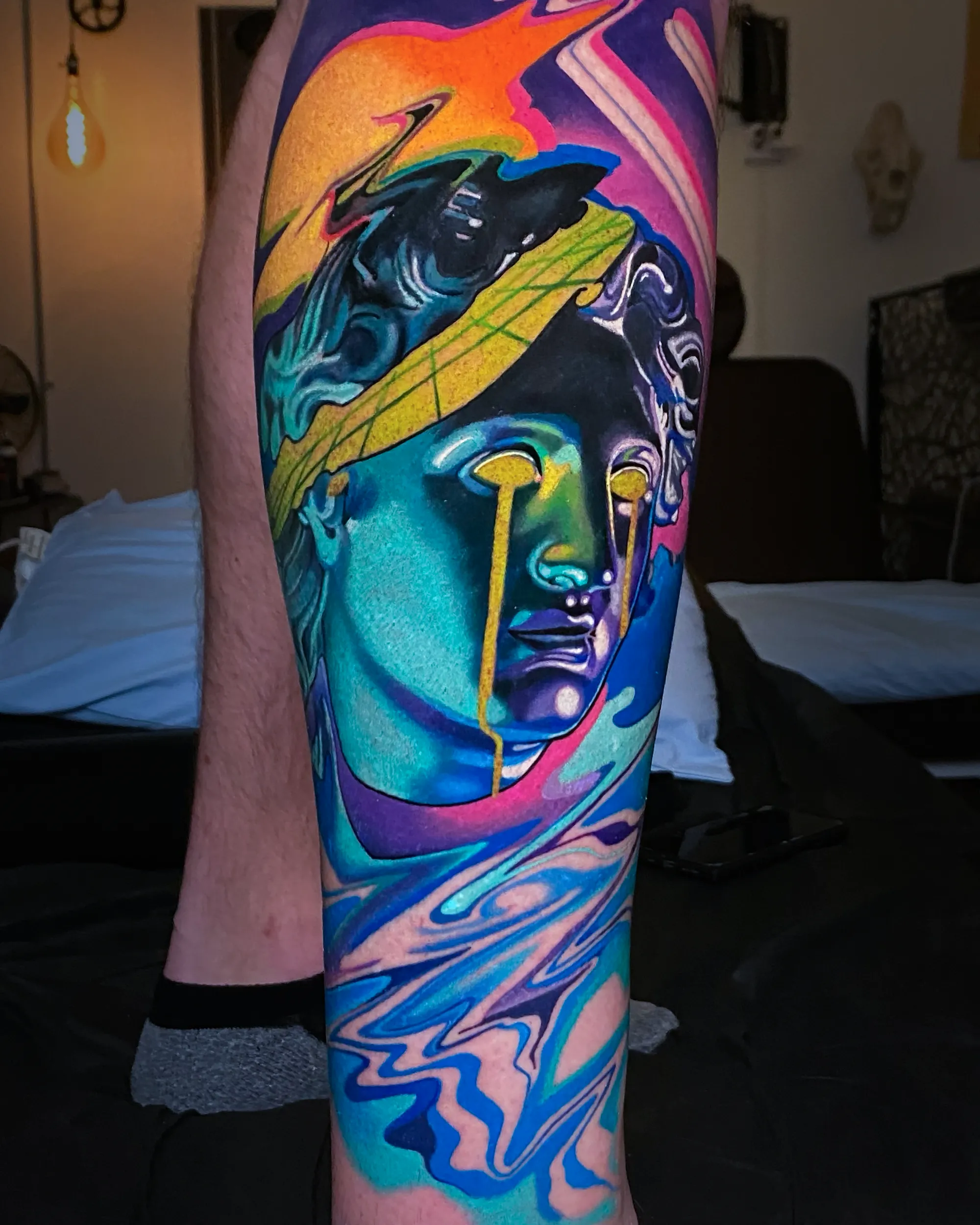 Surreal color weeping Roman statue with psychedelic liquid shin tattoo by Austin tattoo artist Bobby Cupparo