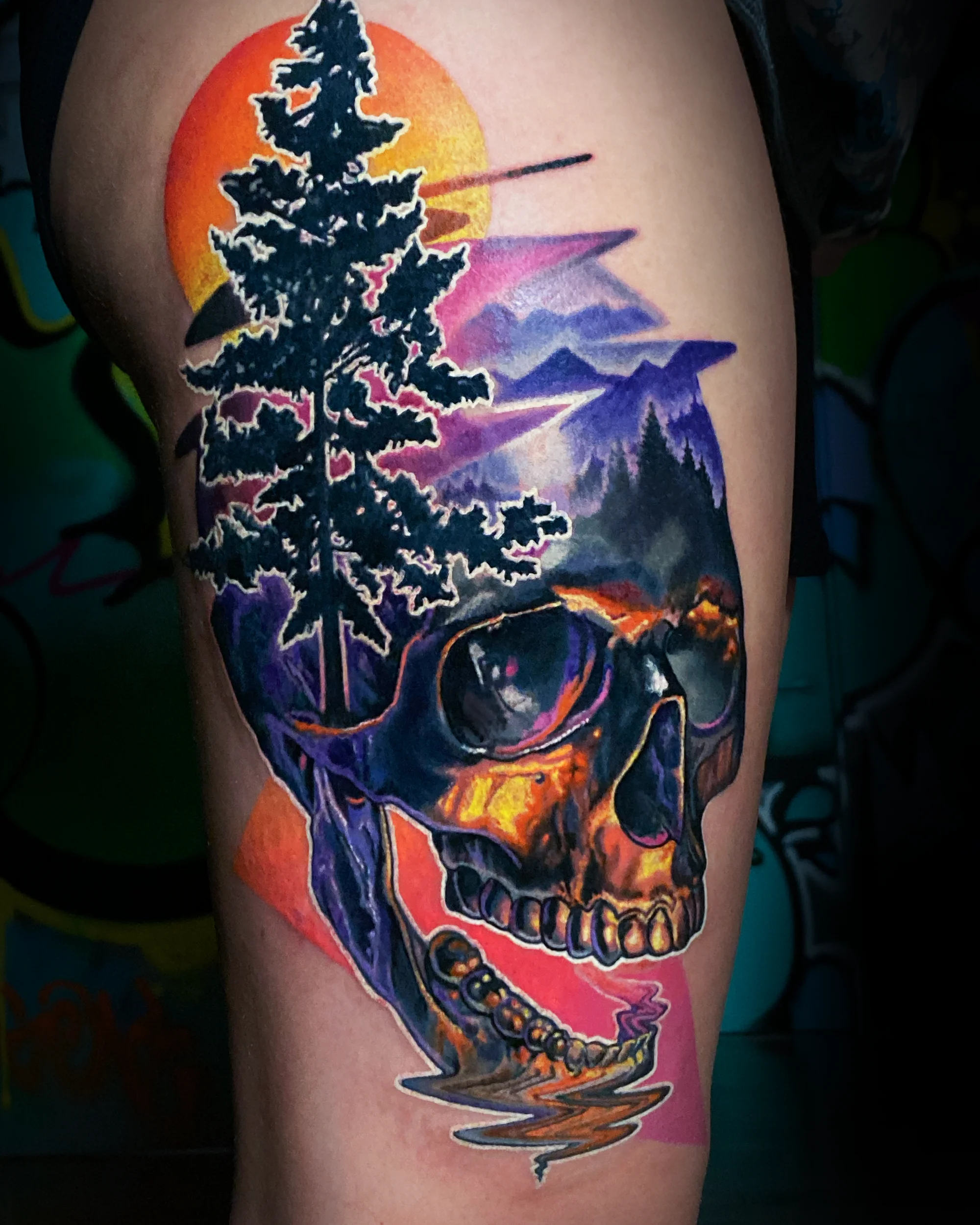 Surreal color skull with pine tree sunset mountain landscape thigh tattoo by Austin tattoo artist Bobby Cupparo