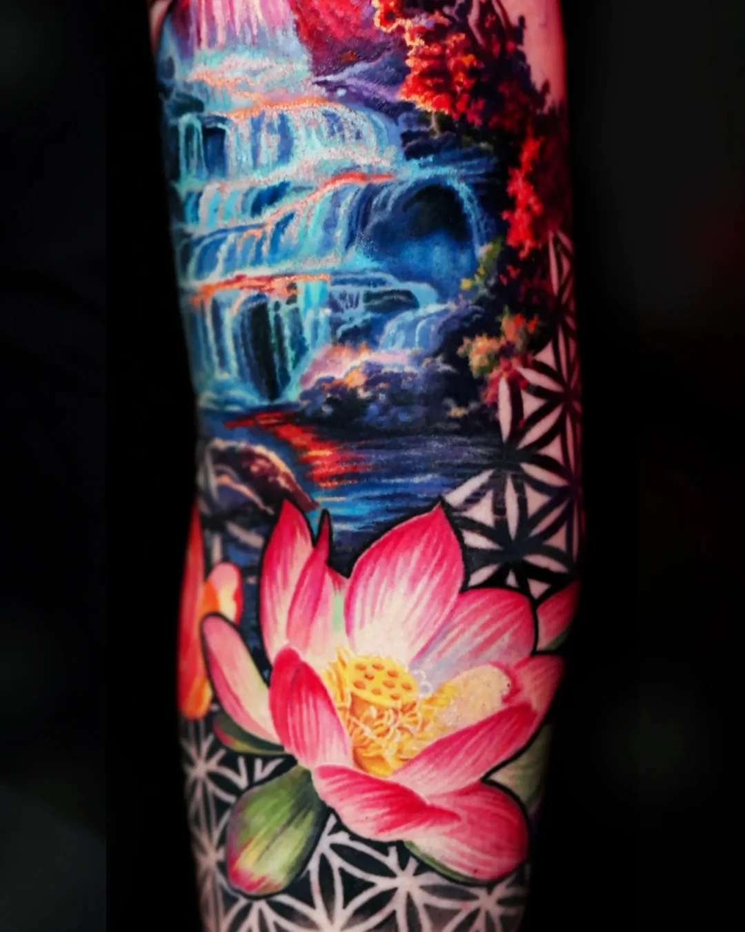 Surreal color realism waterfall with pink lotus and sacred geometry forearm tattoo by Austin tattoo artist Bobby Cupparo