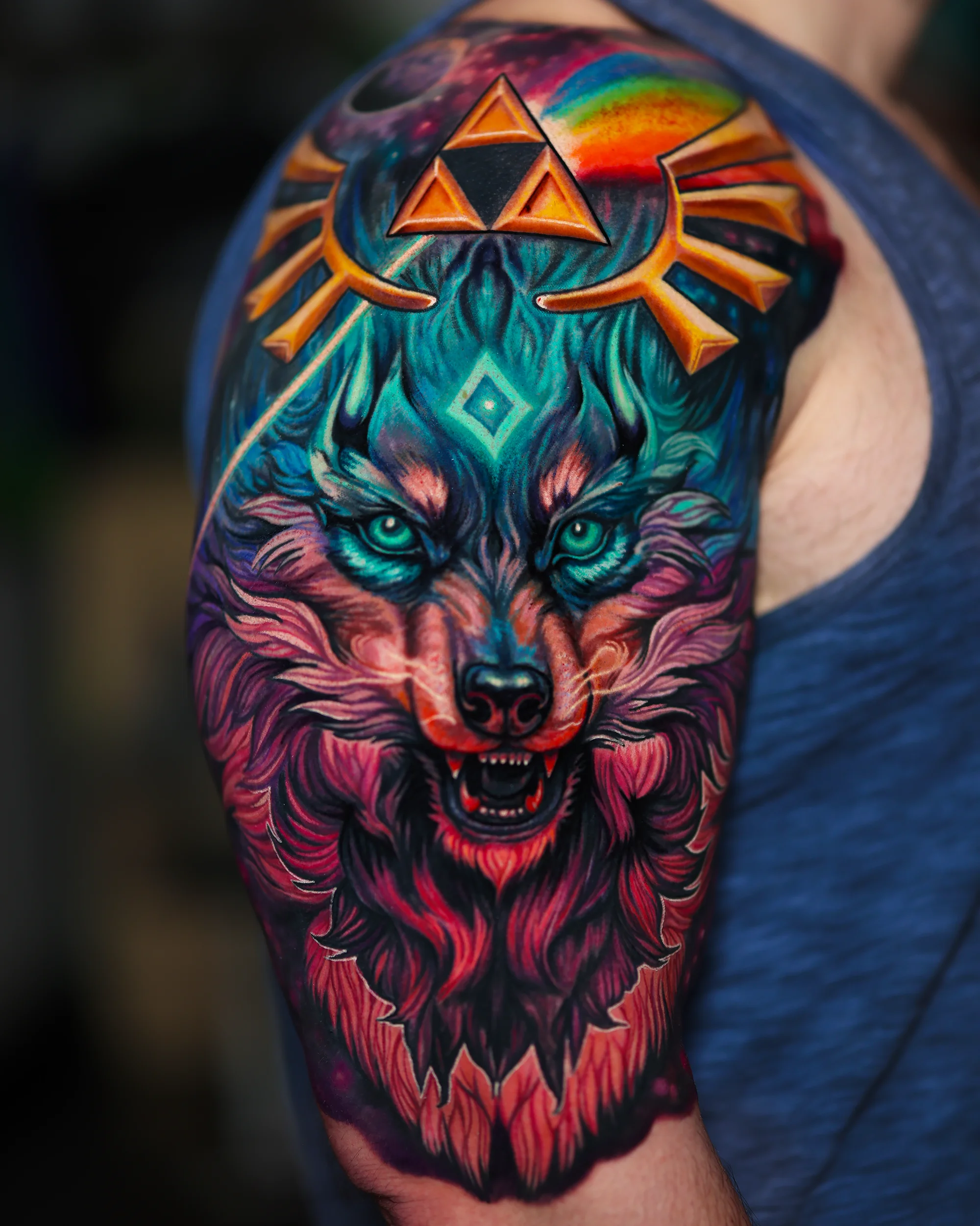 Surreal color Zelda Wolf Link with Triforce rainbow upper arm tattoo by Austin tattoo artist Bobby Cupparo